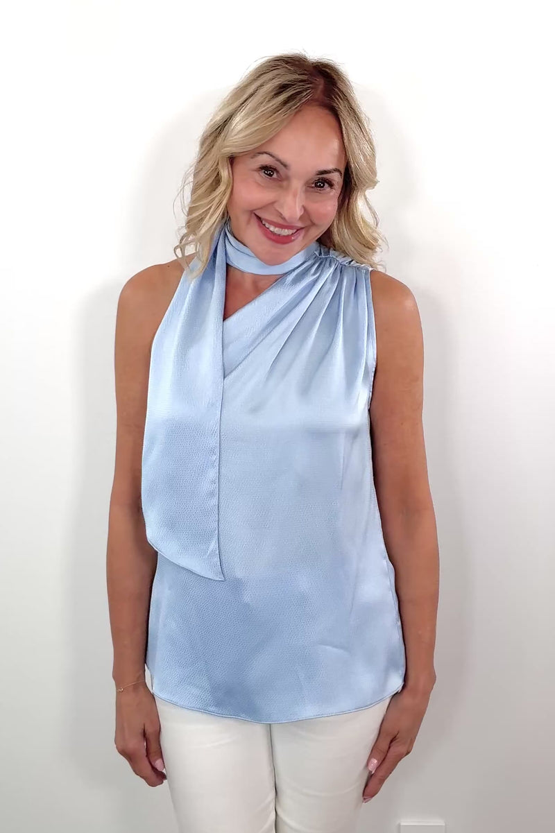Video of Woman wearing a scarf blouse in light blue