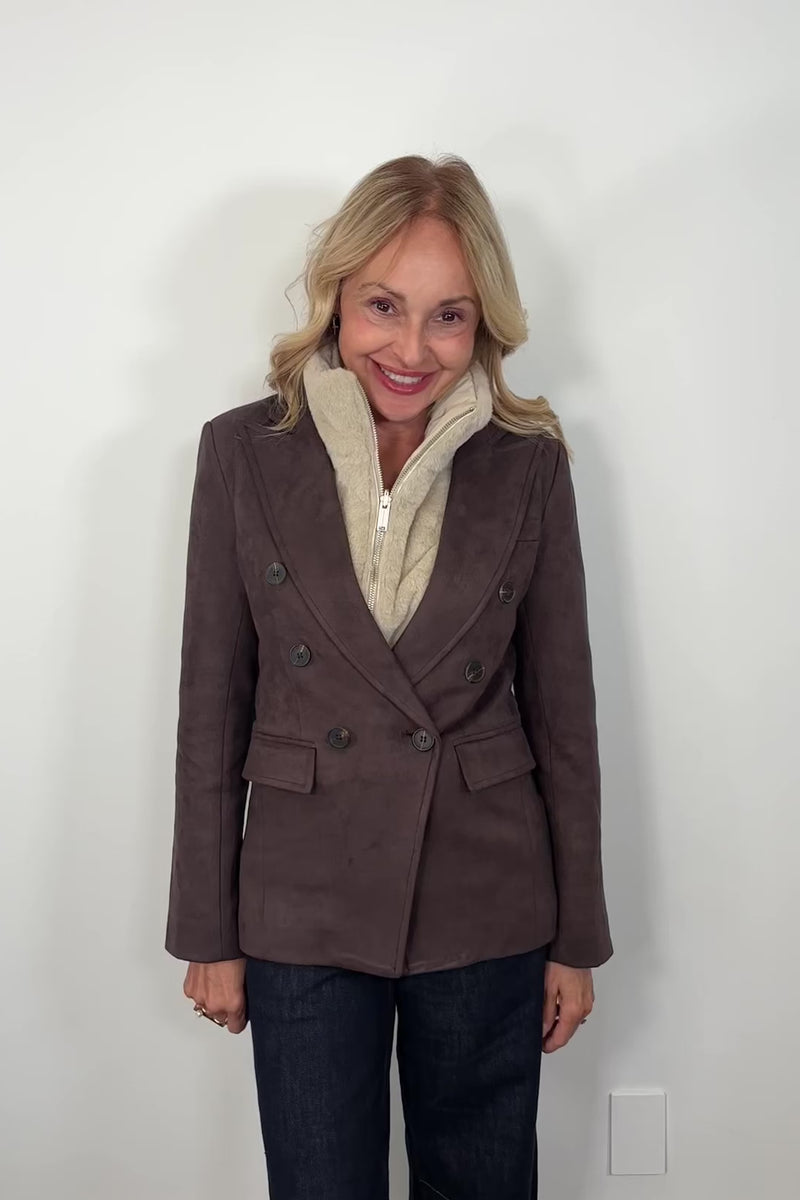 video of woman wearing a brown blazer and ribbed vest