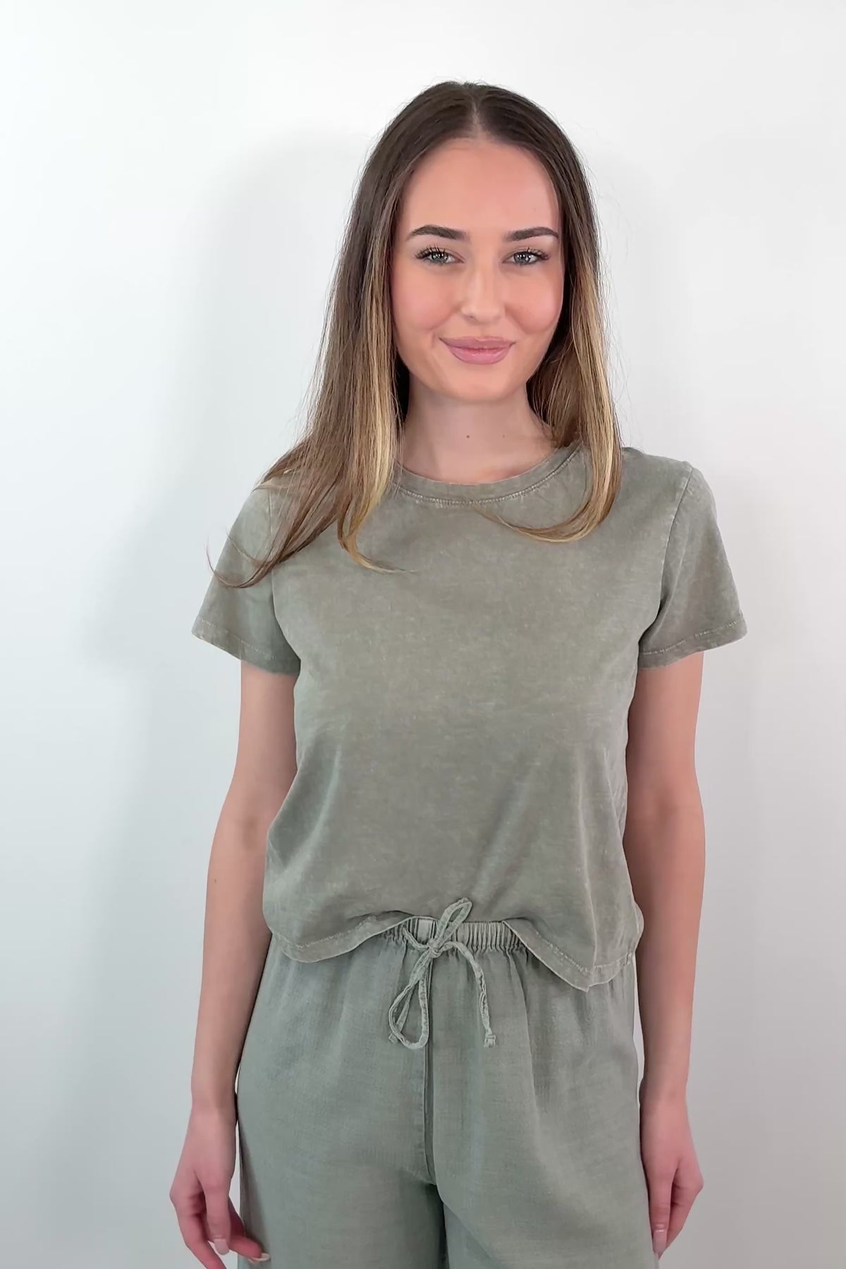 video of a woman wearing a green short sleeved t-shirt