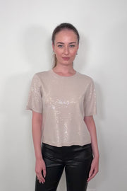 video odds a woman wearing a beige sequin top