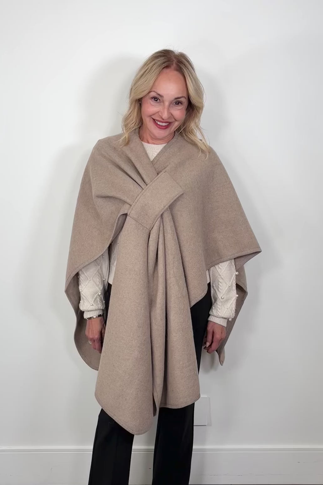 woman wearing a beige cape that looks like a bow