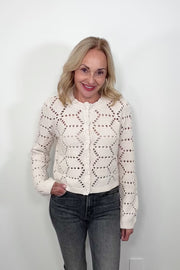 Video of woman wearing an off white knitted cardigan 