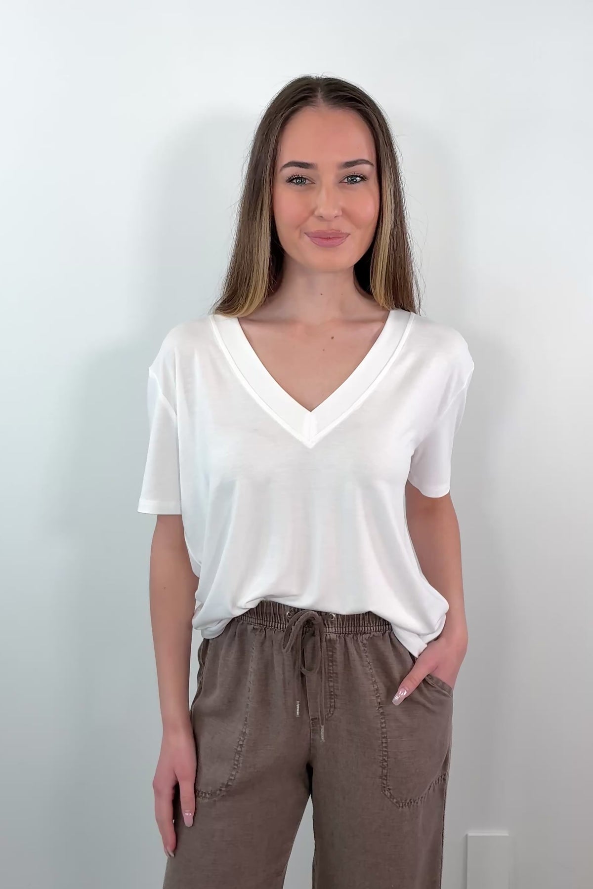 video of a woman wearing a white V-neck t-shirt 