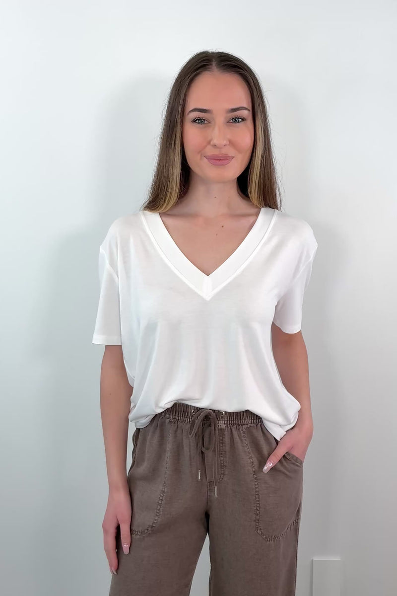 video of a woman wearing a white V-neck t-shirt 