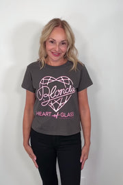 Video of a woman wearing a black t-shirt with pink graphic design