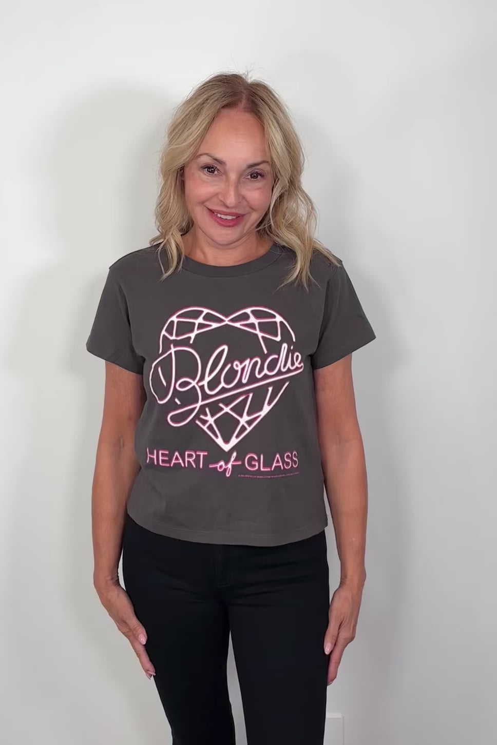 Video of a woman wearing a black t-shirt with pink graphic design