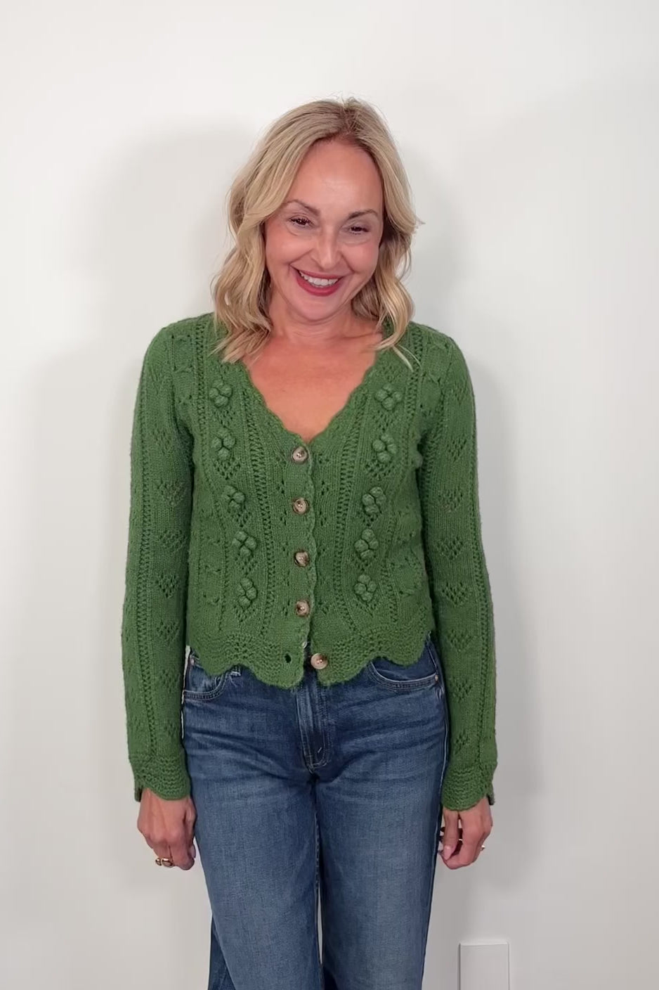 Video of a woman wearing a green knitted cardigan