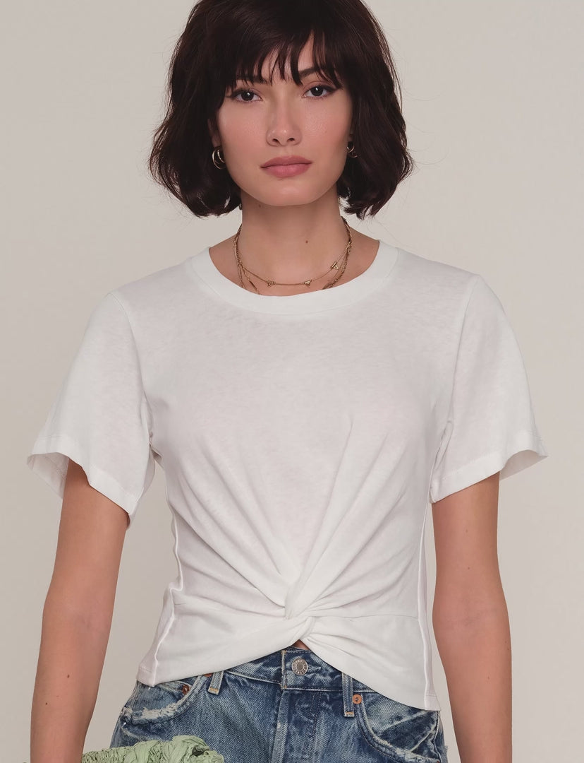 Woman wearing a white t-shirt with front twist detail. 