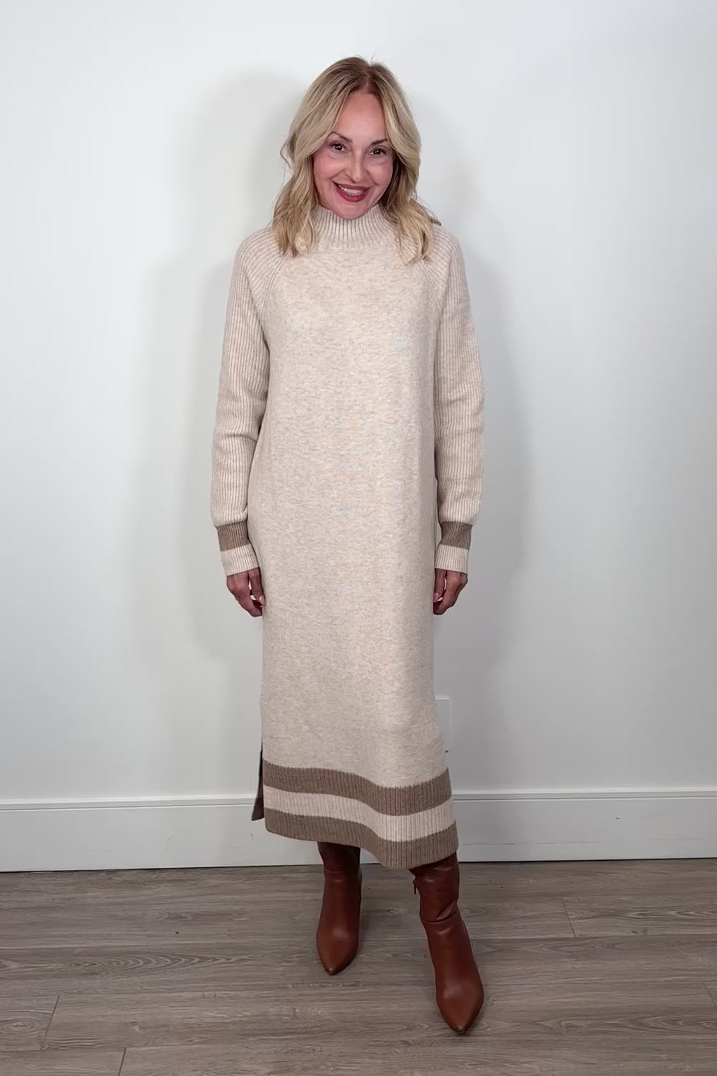 Video of a woman wearing a beige maxi long sleeve mock neck sweater dress