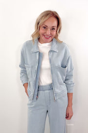 Video of Woman wearing a light blue denim zip front jacket with chest pockets