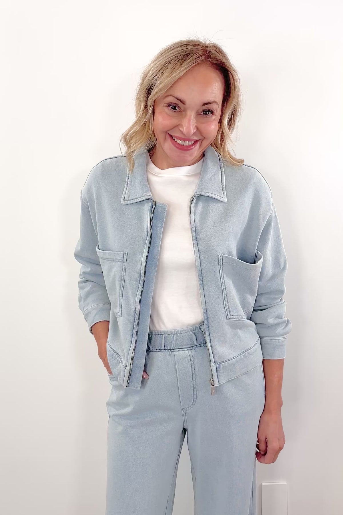 Video of Woman wearing a light blue denim zip front jacket with chest pockets