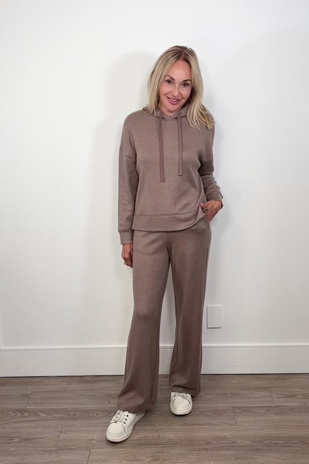 Video of woman wearing light brown lounge set of hoodie and pant