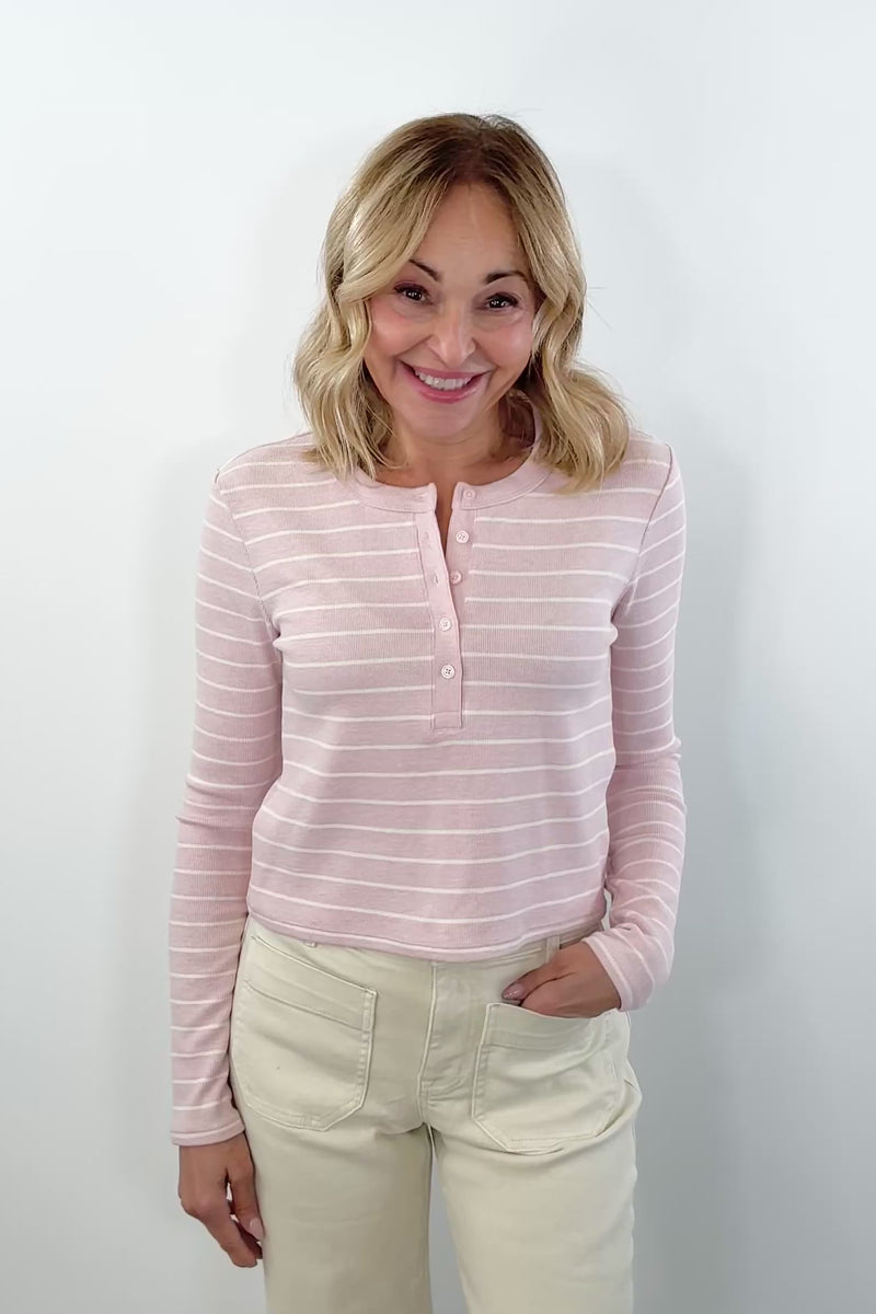 video of woman wearing pink and white striped henley knit top