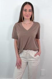 video of a woman wearing a brown V-neck t-shirt 