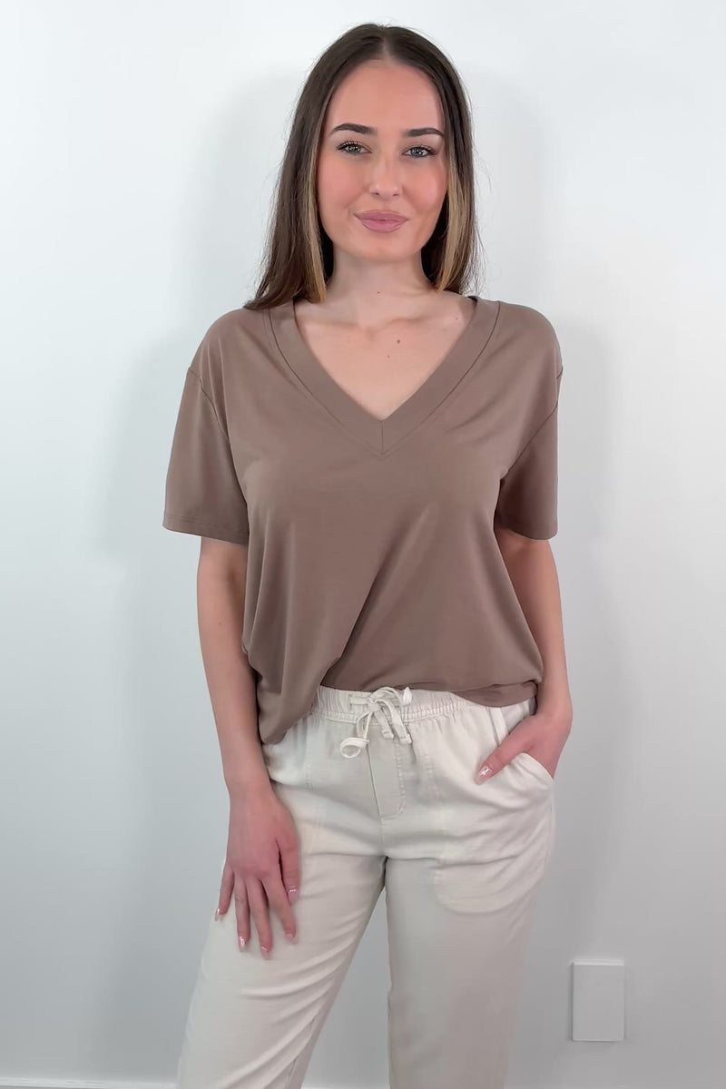 video of a woman wearing a brown V-neck t-shirt 