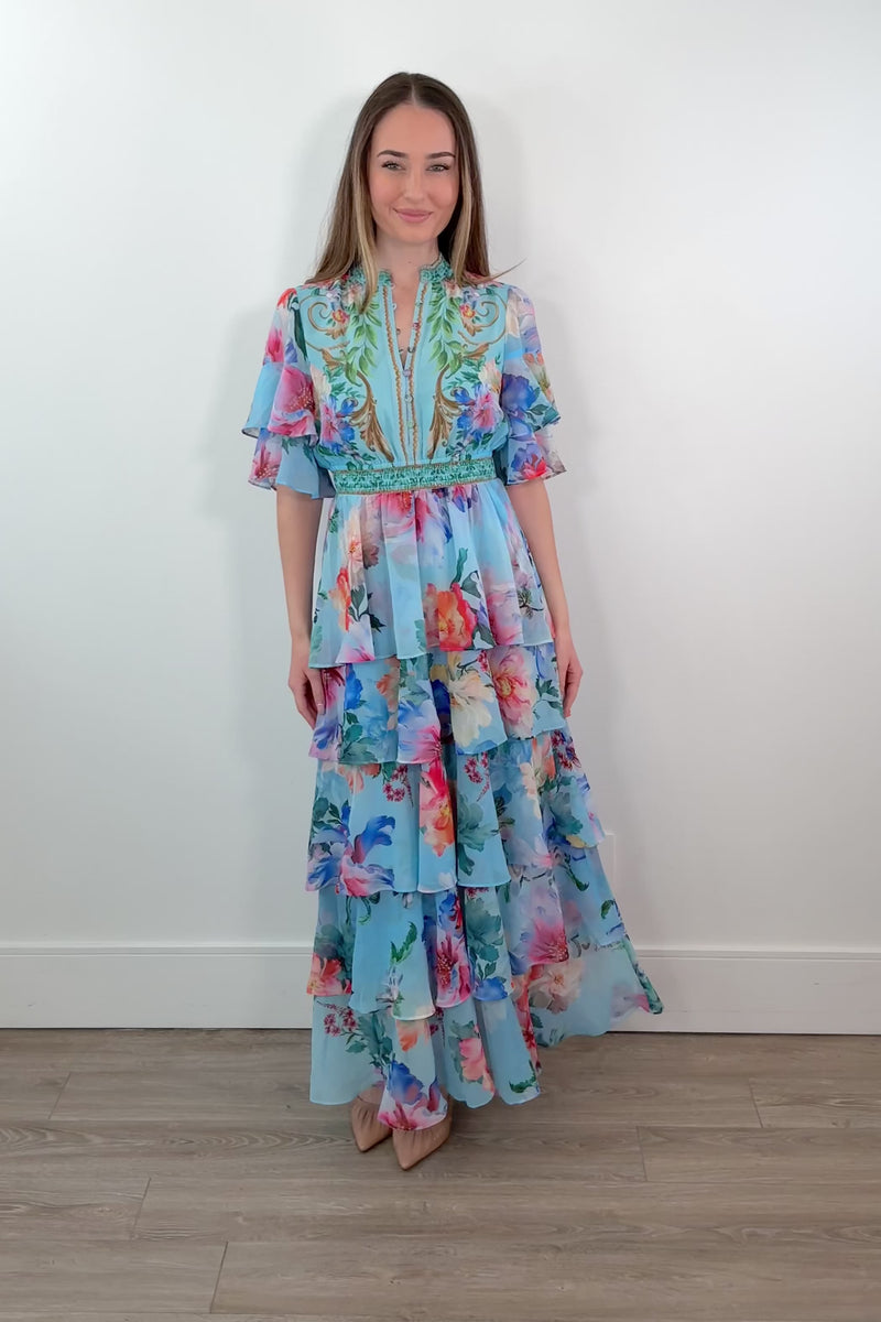video of a woman wearing a teal floral ruffle maxi dress 