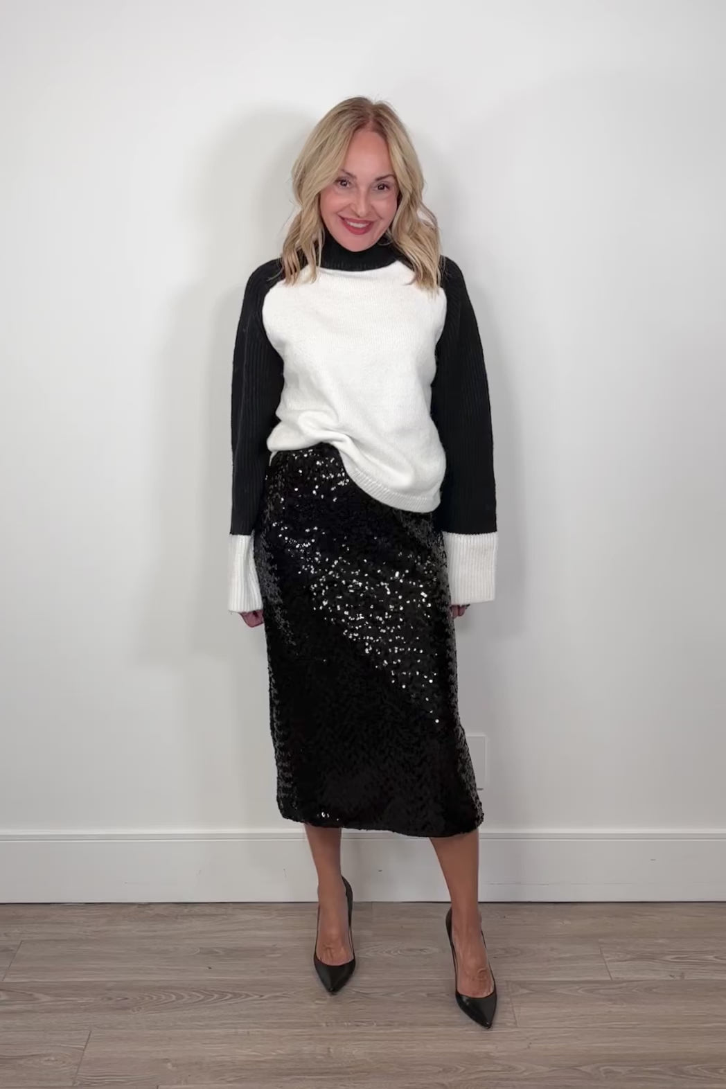 Video of a woman wearing a black midi sequin skirt