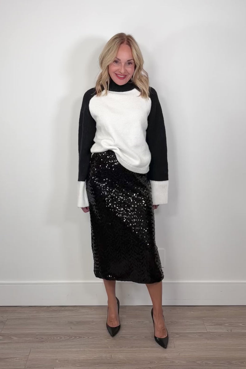 Video of a woman wearing a black midi sequin skirt