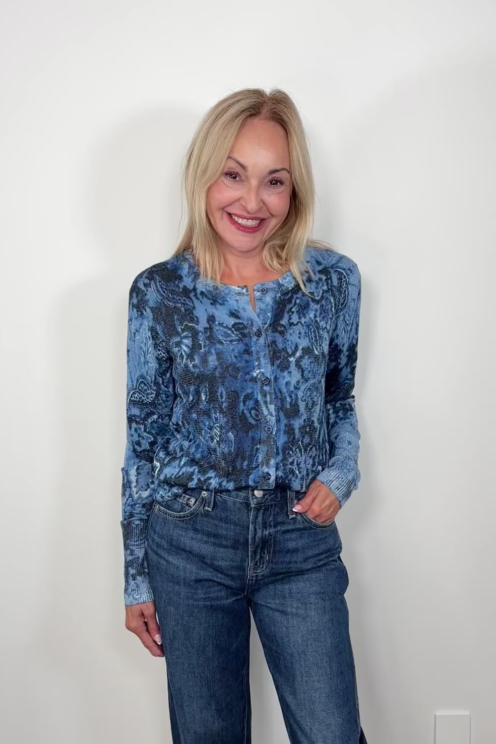 Video of woman wearing a blue patterned thin cardigan open