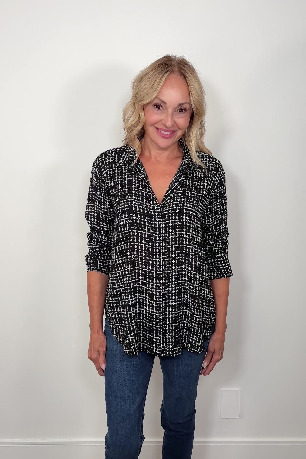 Video of woman wearing a grid printed button down shirt