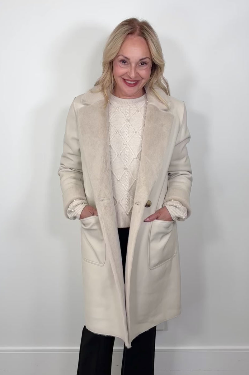 Video of a woman wearing a faux leather reversible trench coat