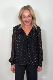 Video of a woman wearing a sheer polka dot blouse