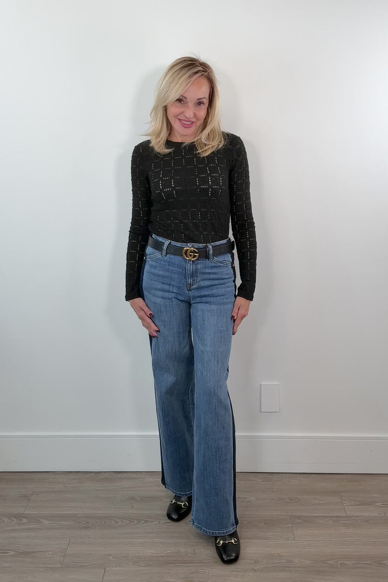 video of a woman wearing blue relaxed straight leg jeans with a navy stripe on the sides