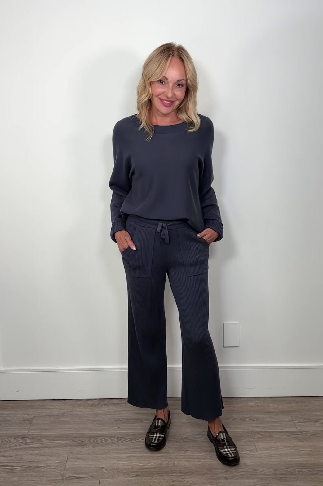 Video of woman wearing blue cashmere blend ribbed pants and sweater turning around to show the back