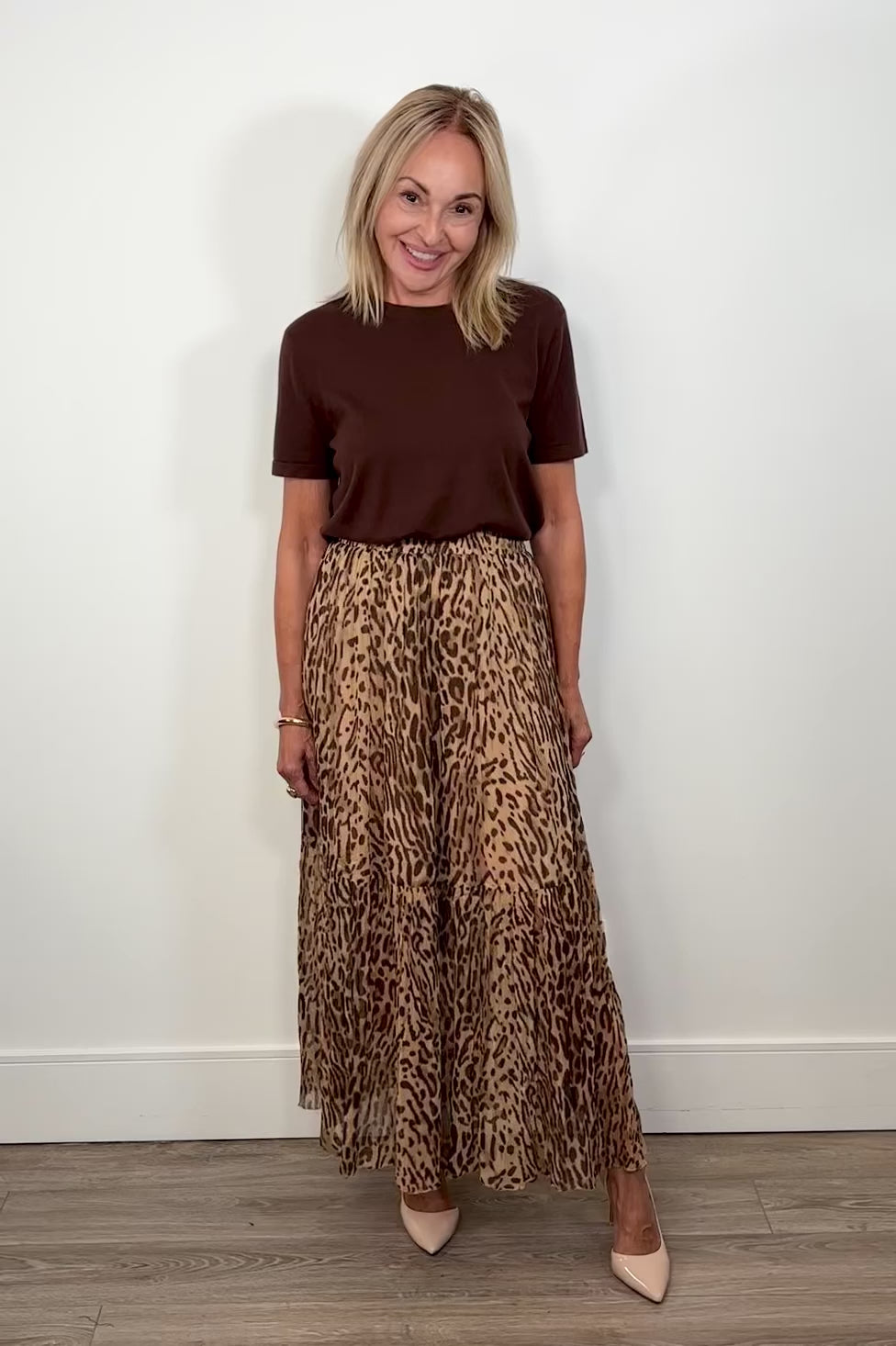 Video of woman wearing a leopard print maxi skirt turning around to show the back