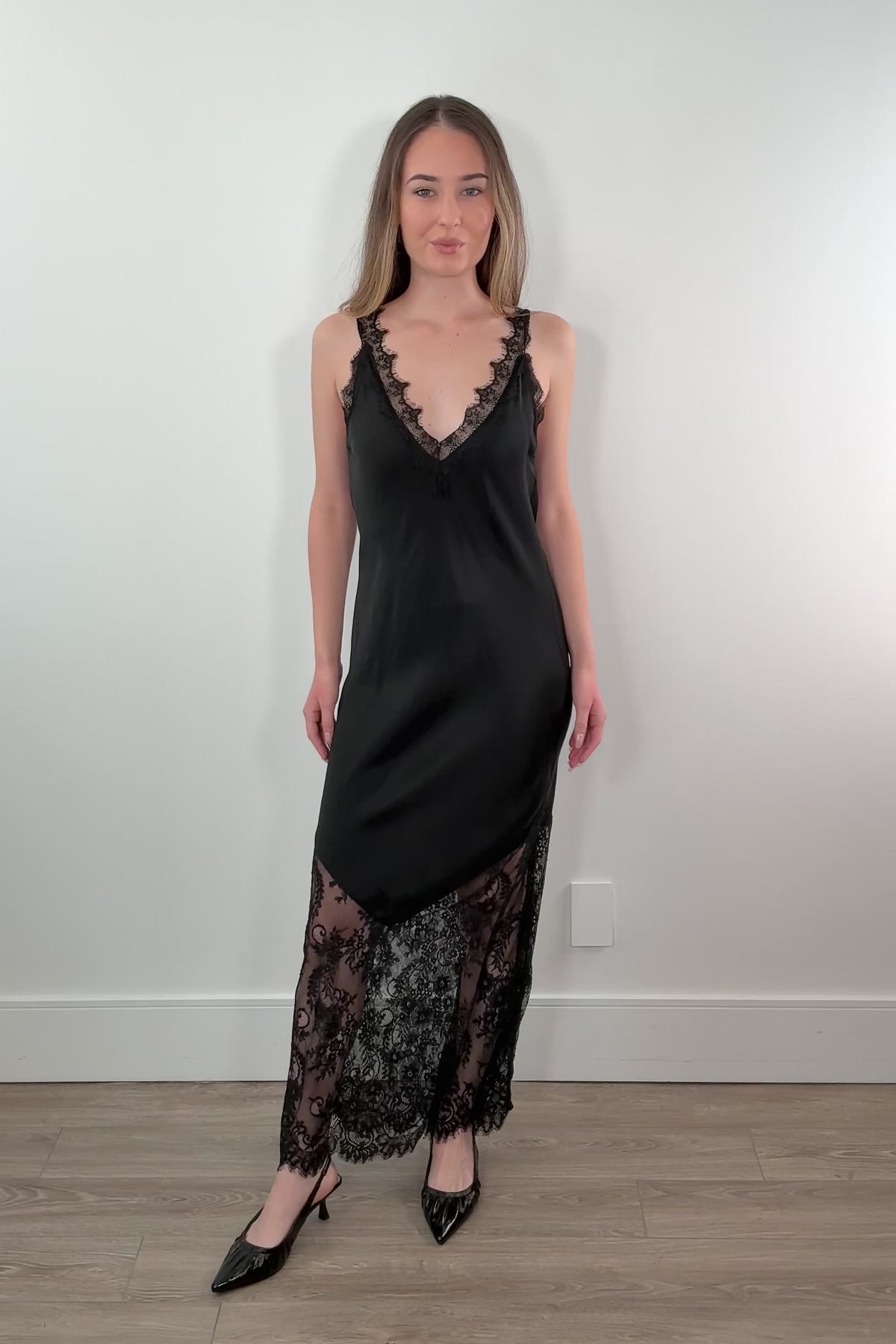 video of a woman wearing a black satin slip dress with lace details