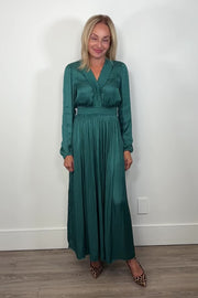 Video of woman wearing a green maxi long sleeve silk dress