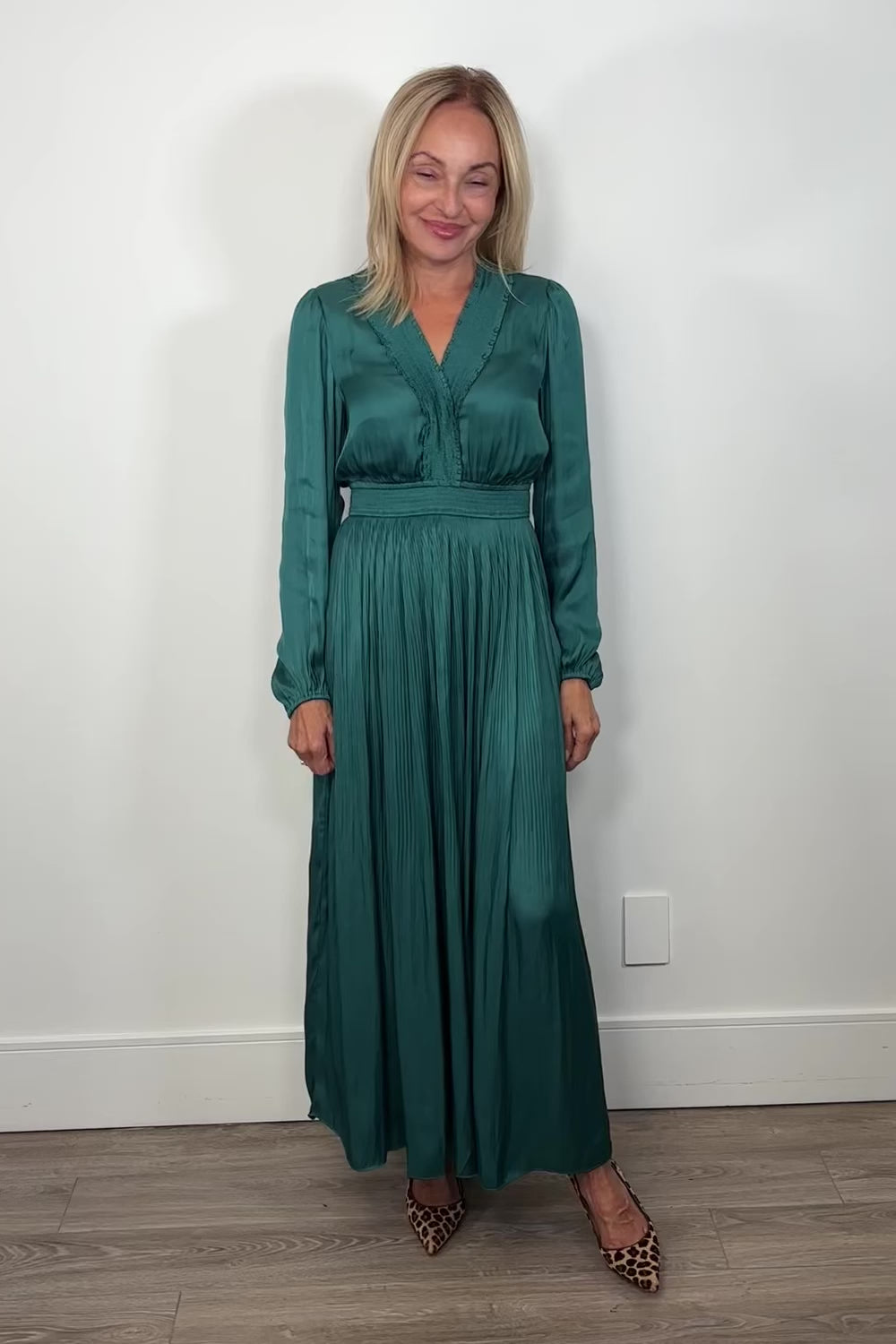 Video of woman wearing a green maxi long sleeve silk dress