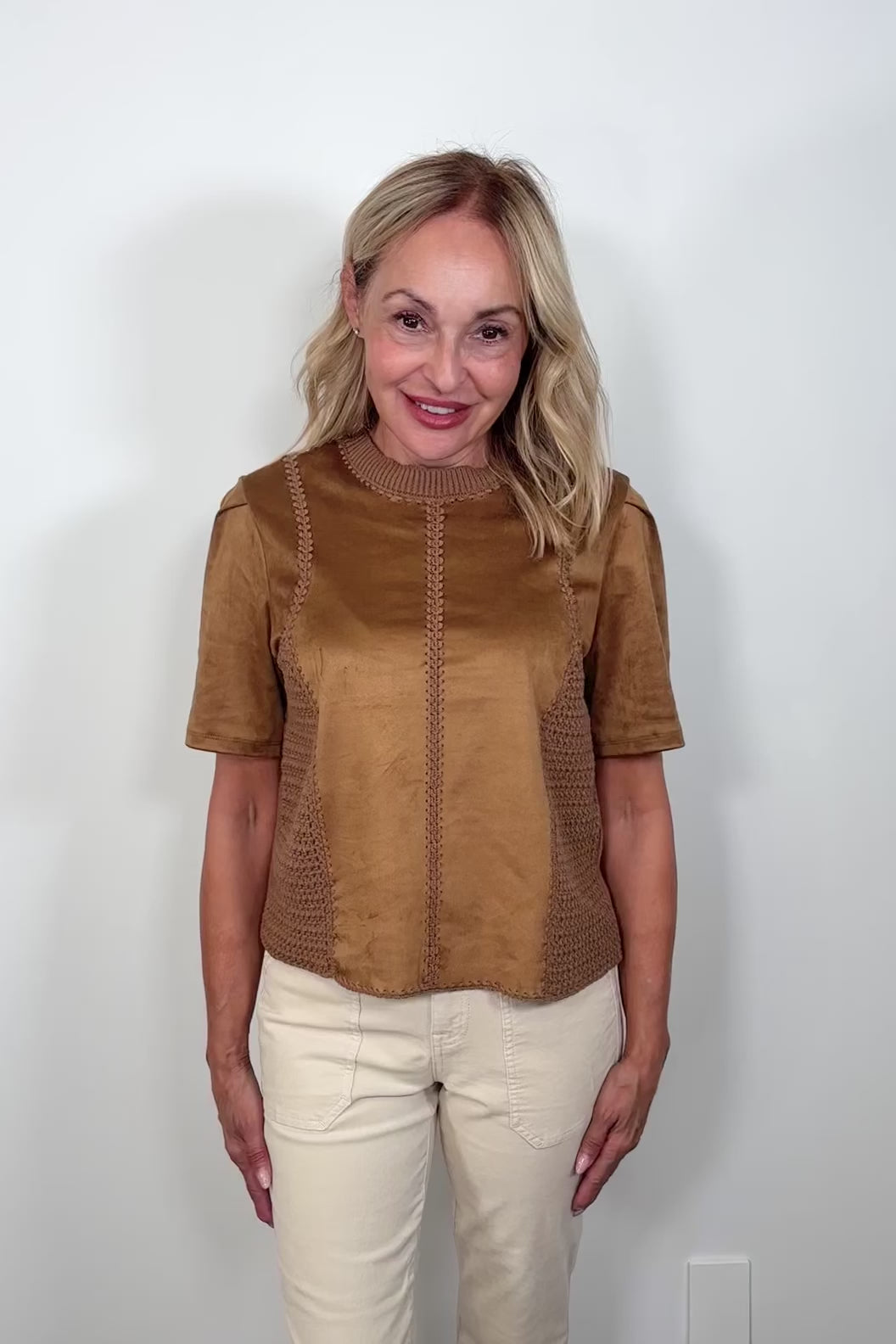 Video of a woman wearing a suede leather and crochet top 