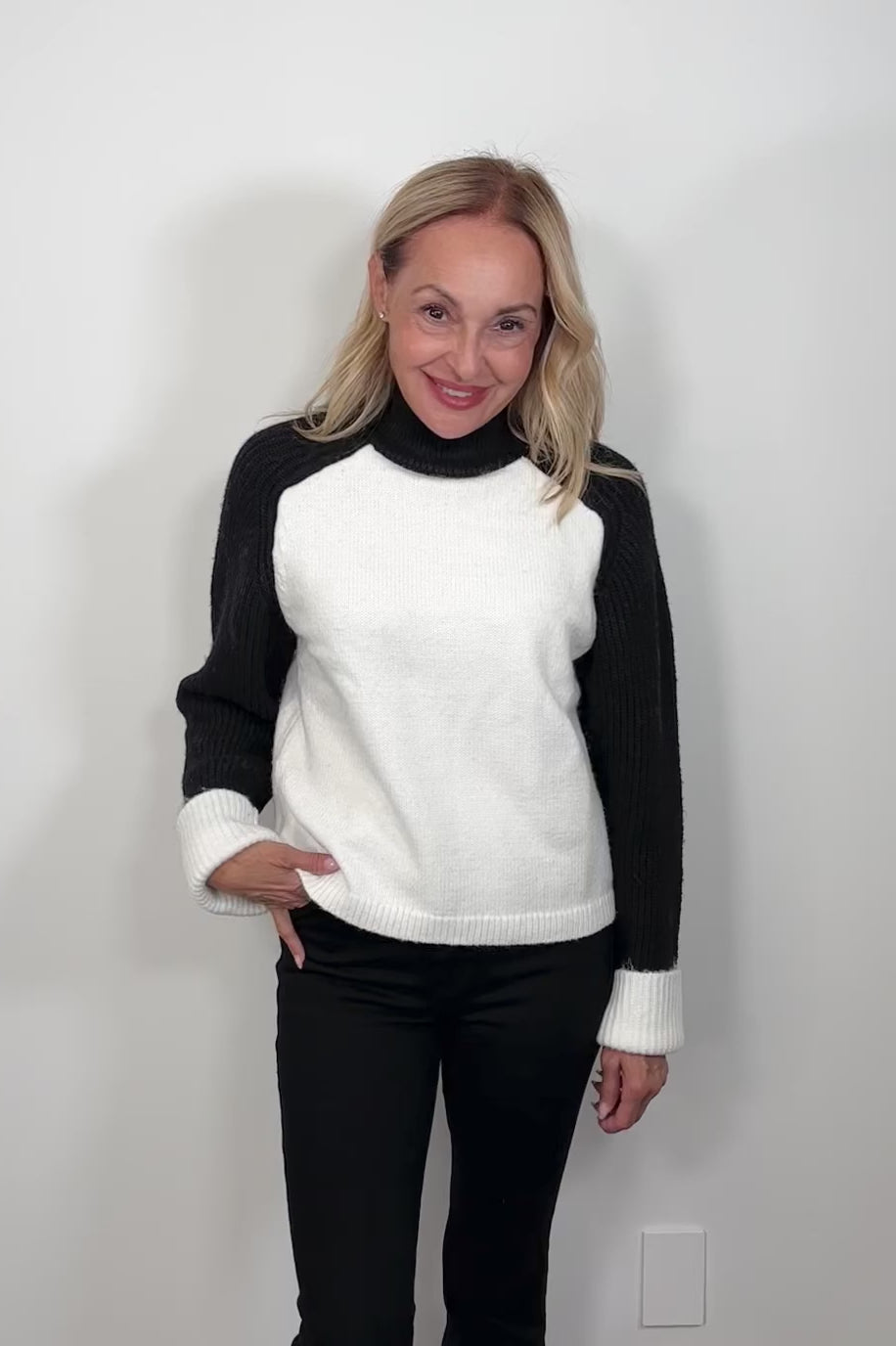 Video of a woman wearing a black and white sweater