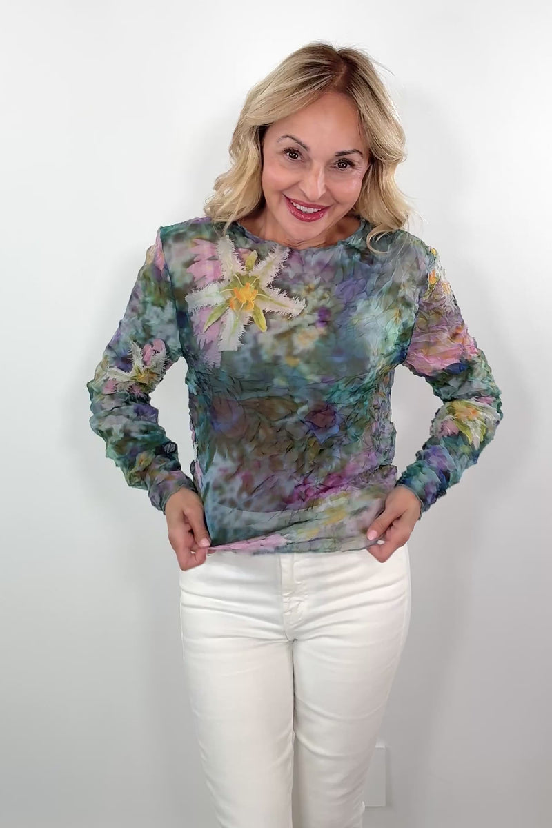 video of a woman wearing a colorful floral long-sleeve sheer top
