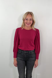 video of a woman wearing a red blouse with puffed sleeves 