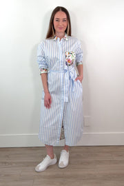 woman wearing a white and blue striped dress with a silk floral patterns