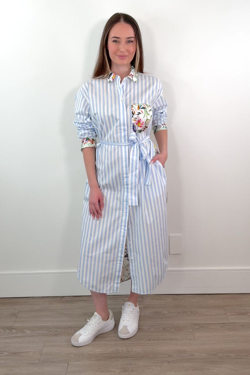 woman wearing a white and blue striped dress with a silk floral patterns