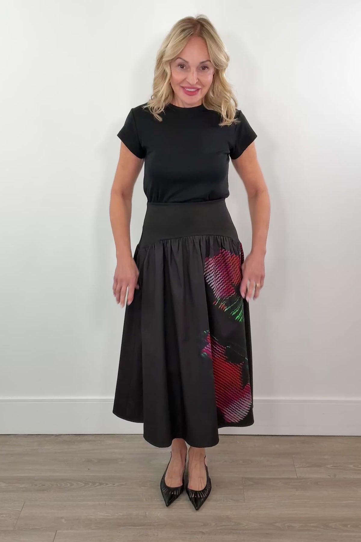 video of a woman wearing a black poplin skirt with a floral design on the side