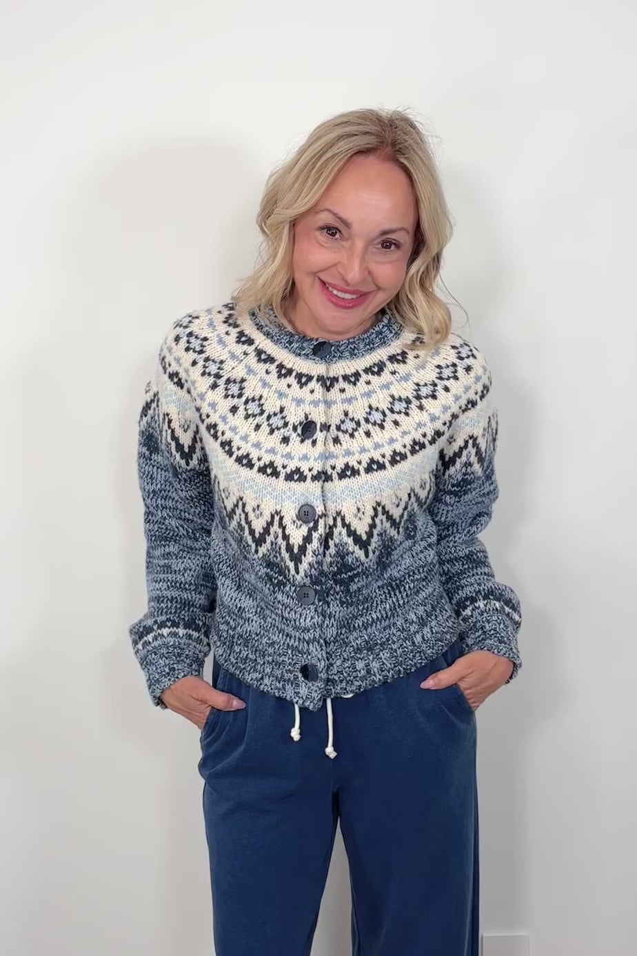 Video of a woman wearing a blue and white patterned sweater against a plain background
