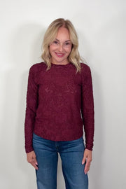 Video of a woman wearing a long sleeve burn out floral tee