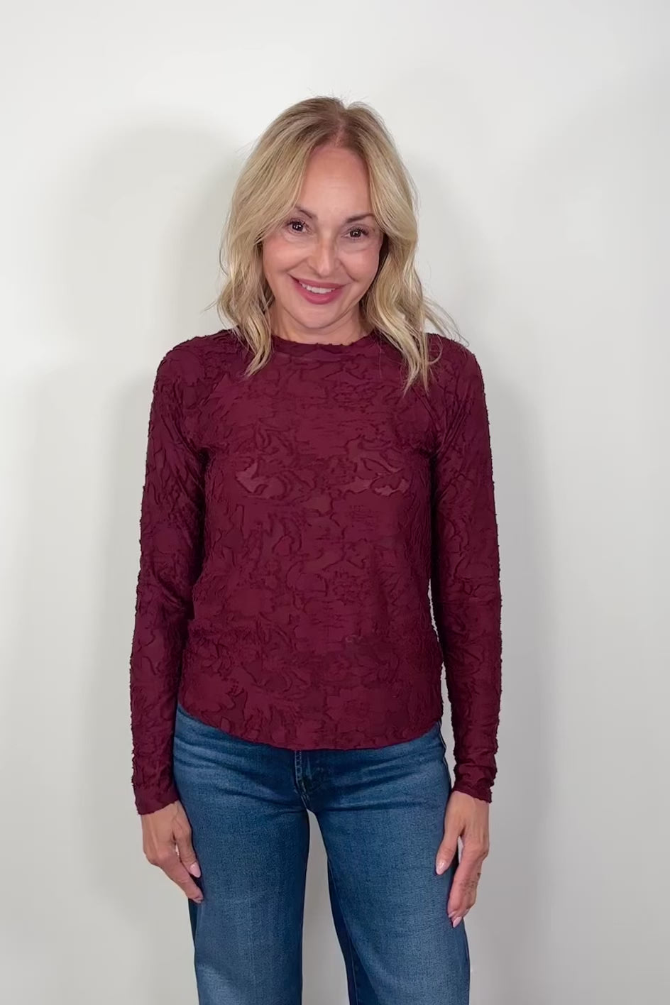 Video of a woman wearing a long sleeve burn out floral tee