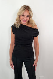 video of a woman wearing a black shimmery jersey off the shoulder sleeveless top