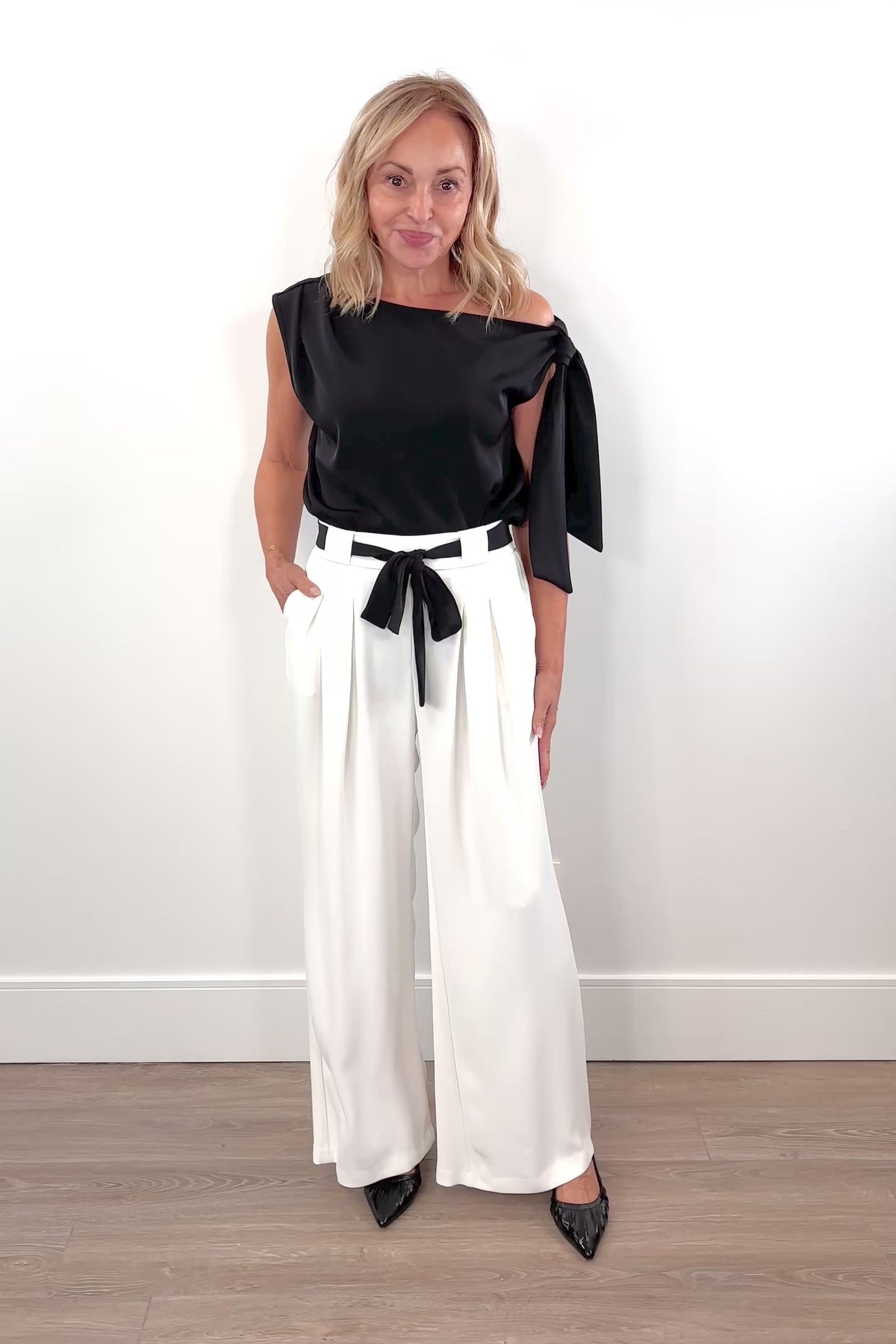 Video of woman wearing a white pant with white shash belt 