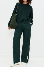 Person wearing a dark green outfit with white stripes on a white background