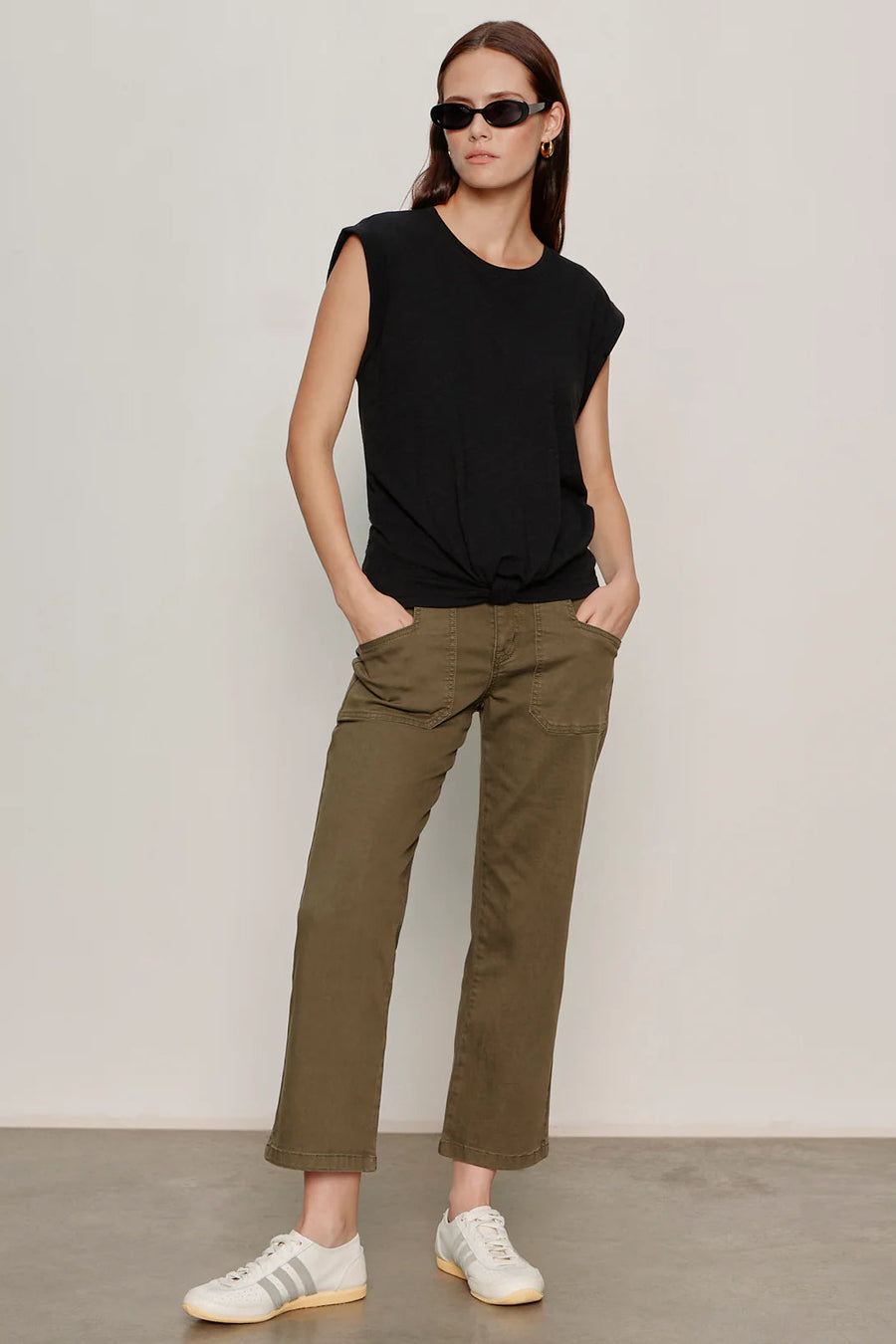 Woman wearing olive green cropped utility pants with a relaxed straight-leg silhouette. Features a high-rise waist, button and zip closure, oversized front patch pockets, and utility-inspired seam detailing. Crafted from soft stretch twill for everyday comfort and ease of movement, front