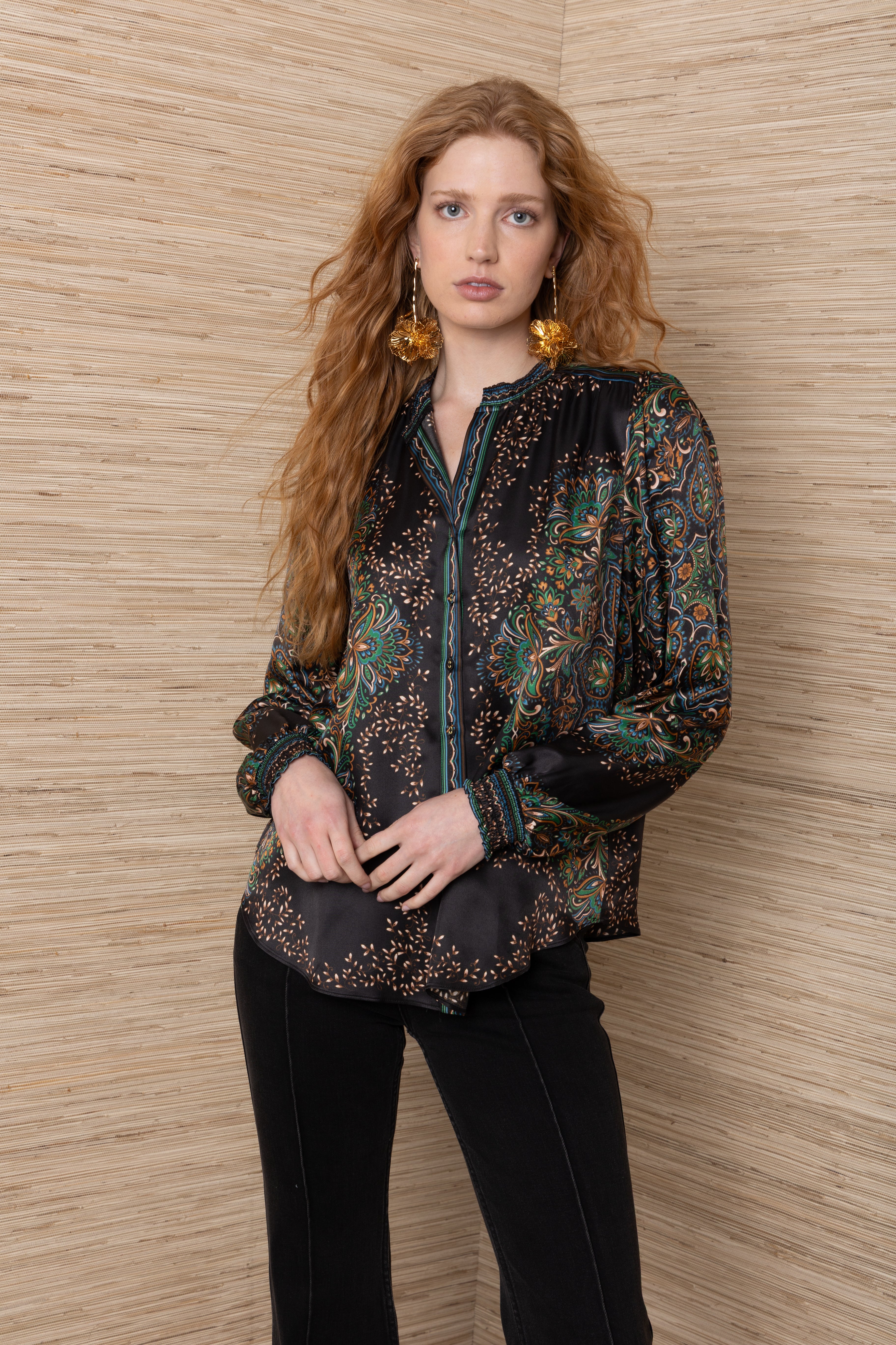 woman wearing a black button up blouse with green and orange detailing