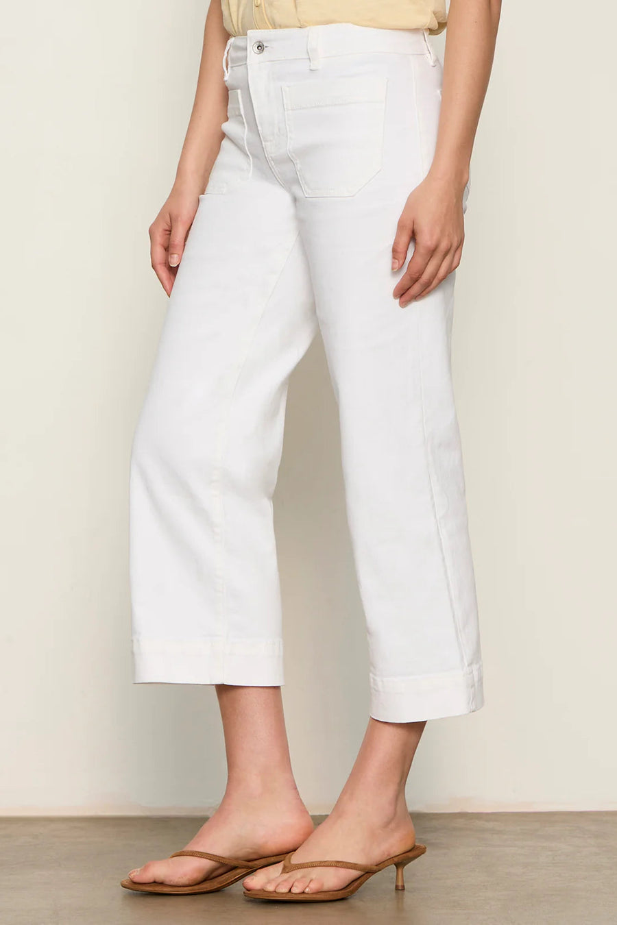 Woman wearing white high-waisted cropped straight-leg pants, side