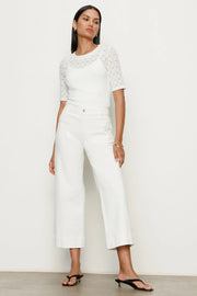 Woman wearing white high-waisted cropped straight-leg pants, front