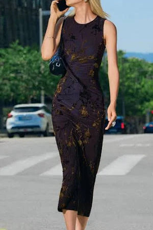 woman wearing a bown tight patternd dress with golden brown leaf designs 